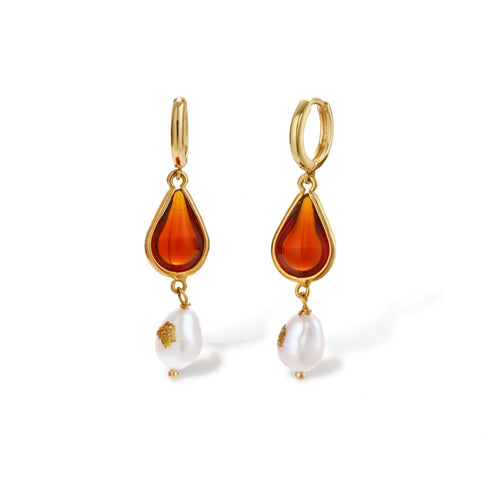 Gold-plated drop earrings featuring amber teardrops and white baroque pearls on light background.