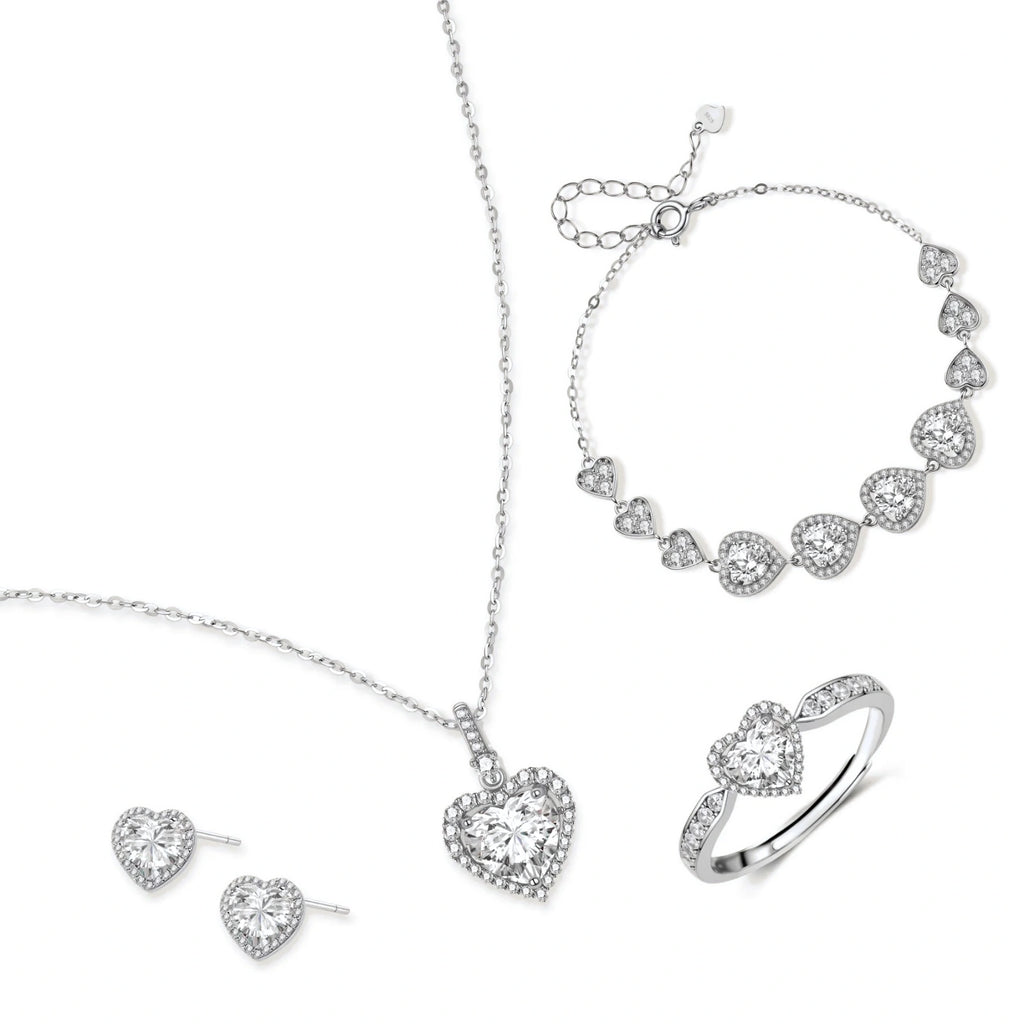 Complete jewelry set with heart-shaped sterling silver pieces featuring brilliant moissanite stones on white background.