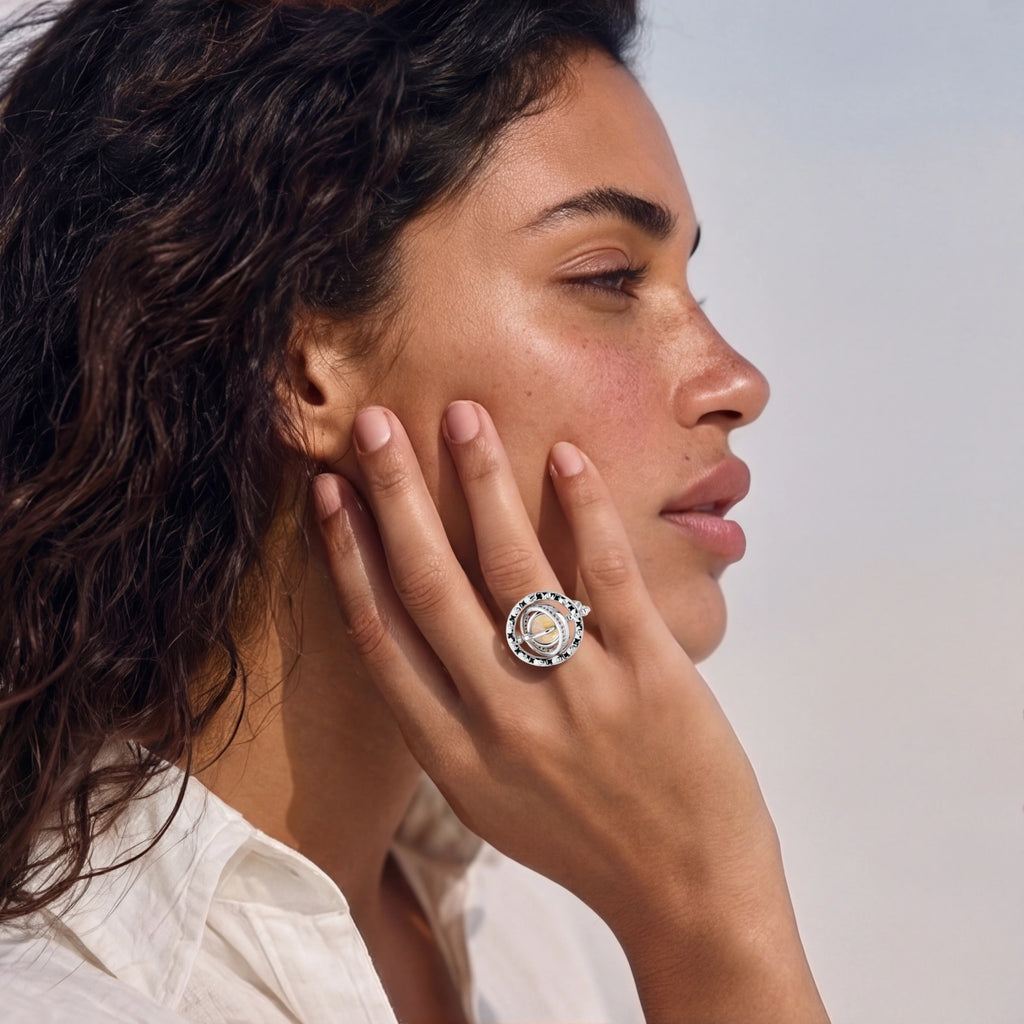 Woman wearing a silver ring with a circular design on a neutral background