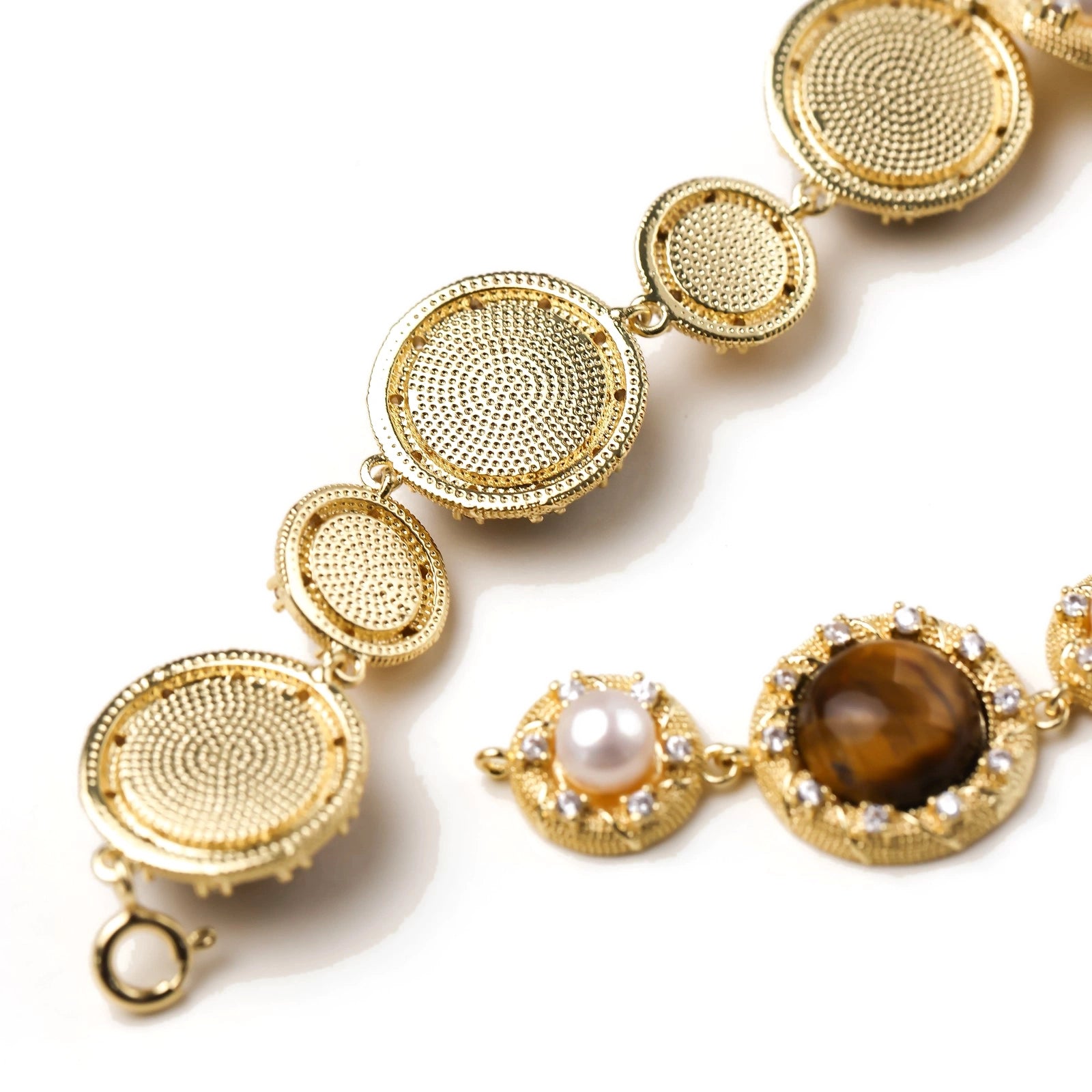 Gold-plated link bracelet with alternating brown tiger's eye stones and white freshwater pearls in ornate bezels.