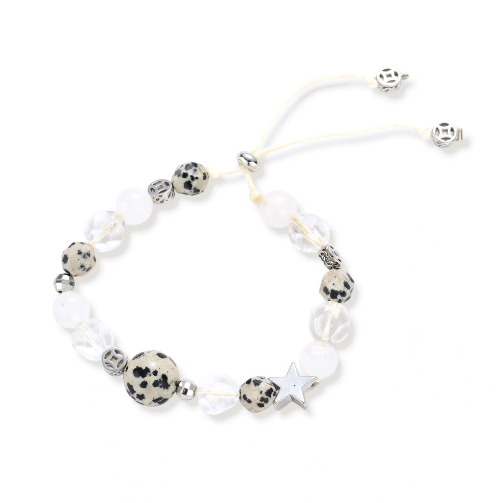 Adjustable beaded bracelet with spotted dalmatian stones, clear quartz crystals, and silver star charm on white background.