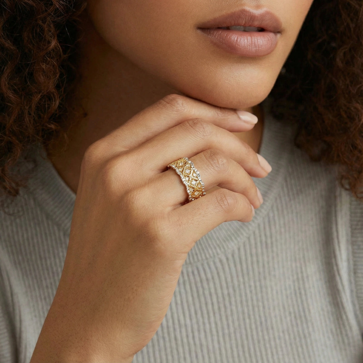 Close-up of a woman's hand wearing a gold ring with intricate design.