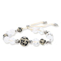 Adjustable beaded bracelet with spotted dalmatian stones, clear quartz crystals, and silver star charm on white background.