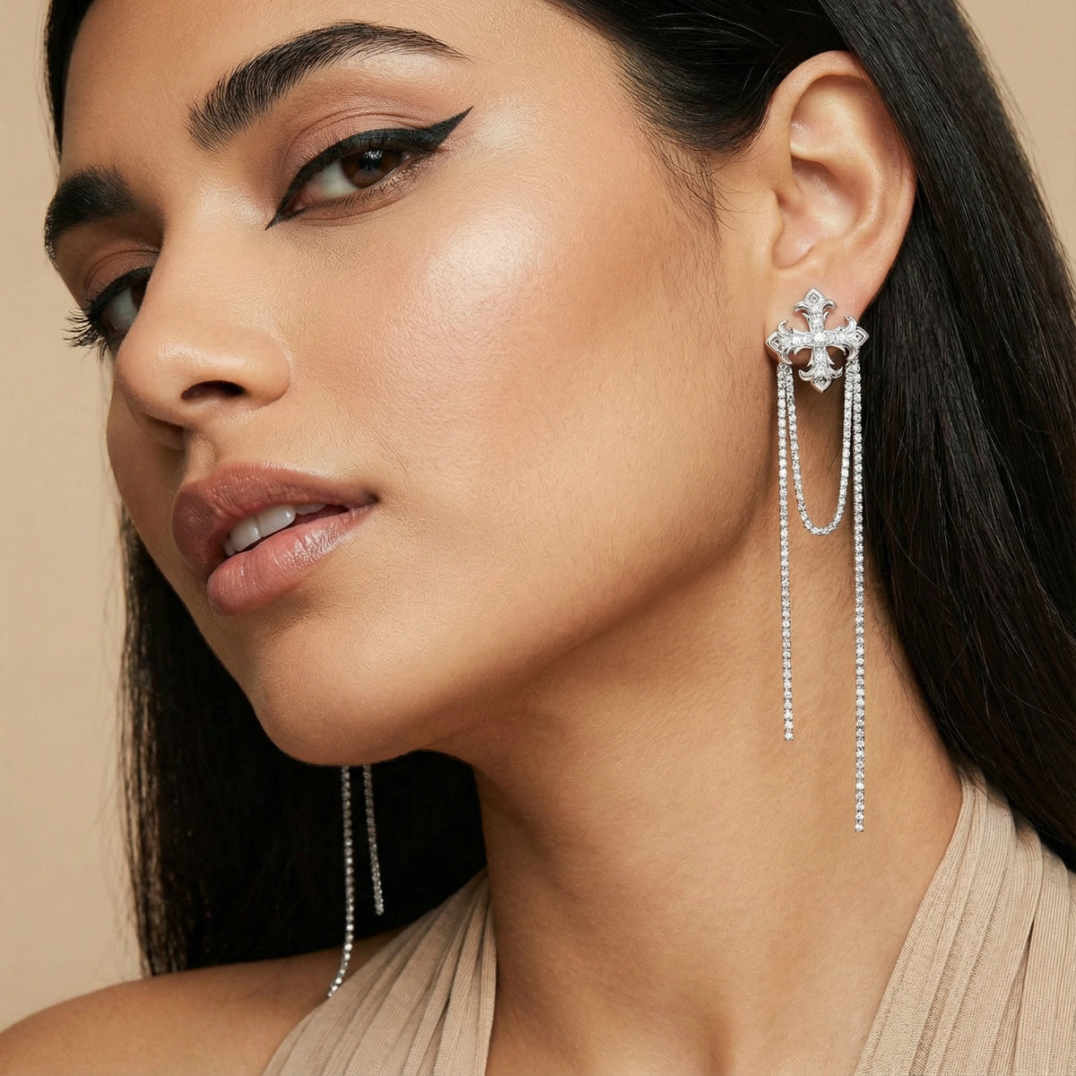 Close-up of a woman wearing elegant earrings with a neutral background