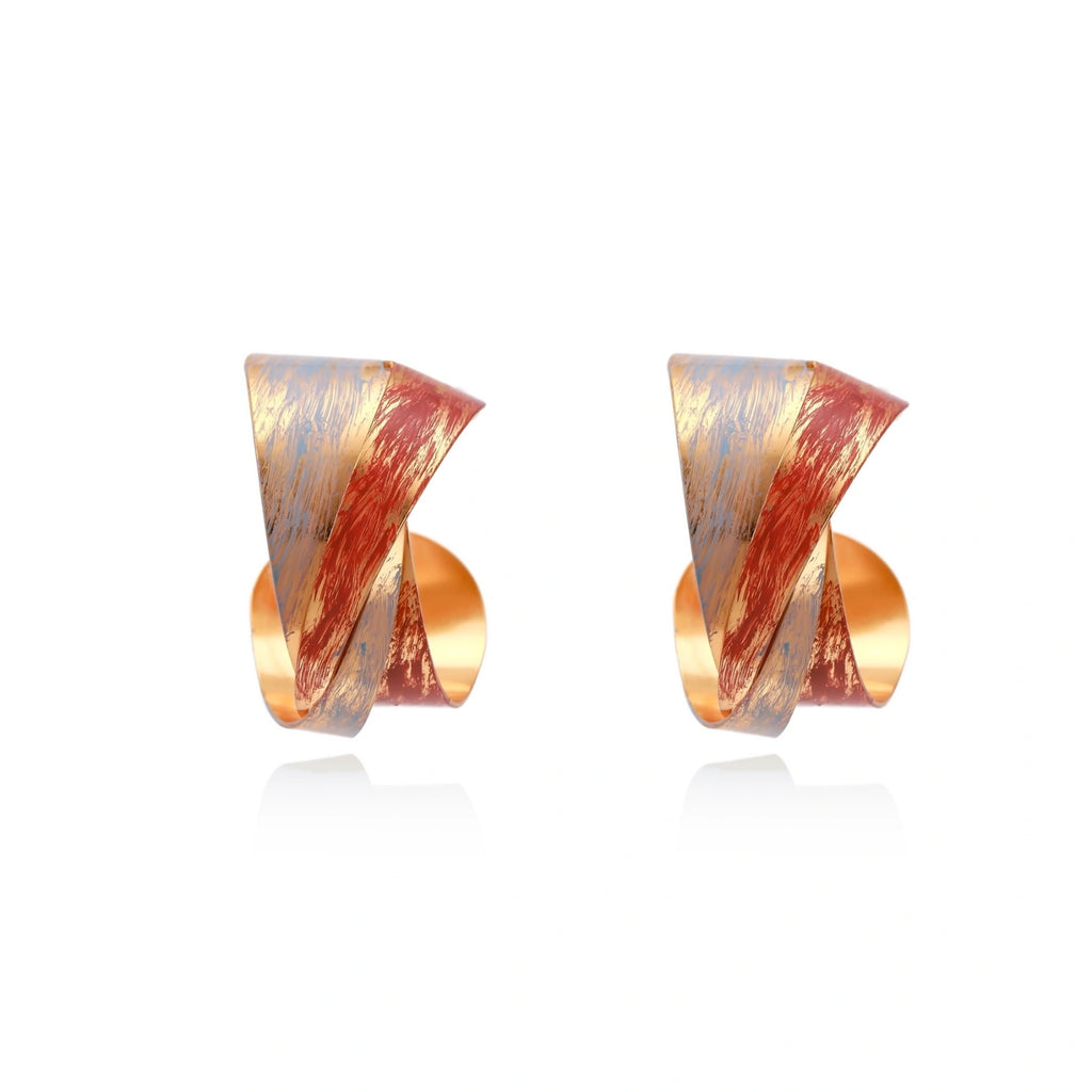 Sculptural gold-plated hoop earrings with diagonal purple and coral enamel stripes in twisted ribbon design