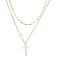 Three-layered gold necklace set with graduated cross pendants in mixed chain styles on white background.