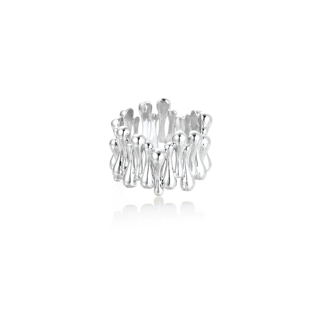 Wide band ring with sculptural wave ripples in polished white gold plated eco-brass on cream background
