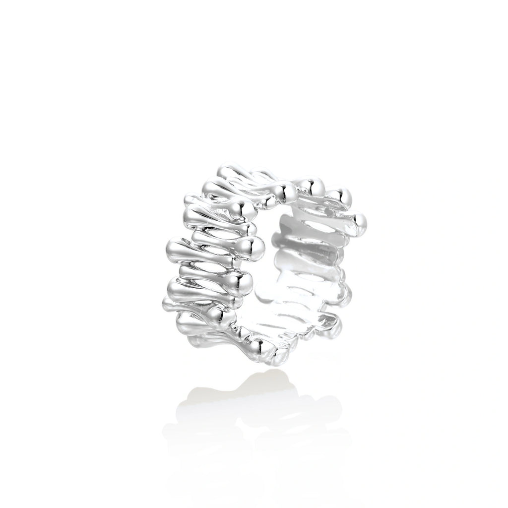 Wide band ring with sculptural wave ripples in polished white gold plated eco-brass on cream background