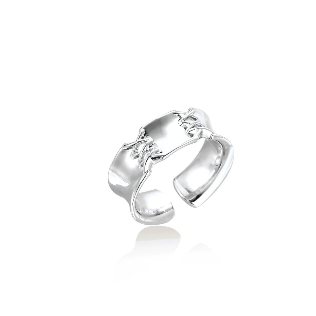 Adjustable silver-toned ring with sculptural stitch design across polished white gold-plated brass band