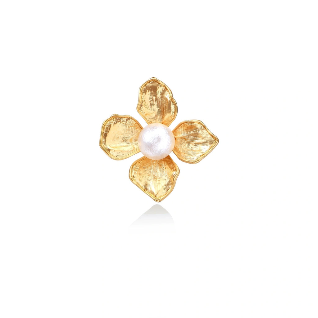 Gold-plated flower ring with textured petals and white cotton pearl center on cream background