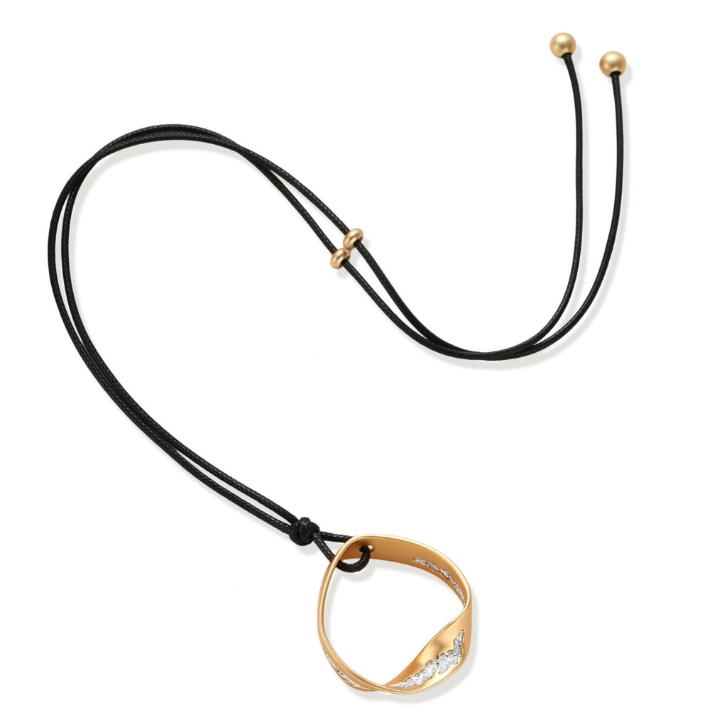 Geometric circle pendant necklace with crystal cluster on adjustable black cord, available in gold and silver finishes.