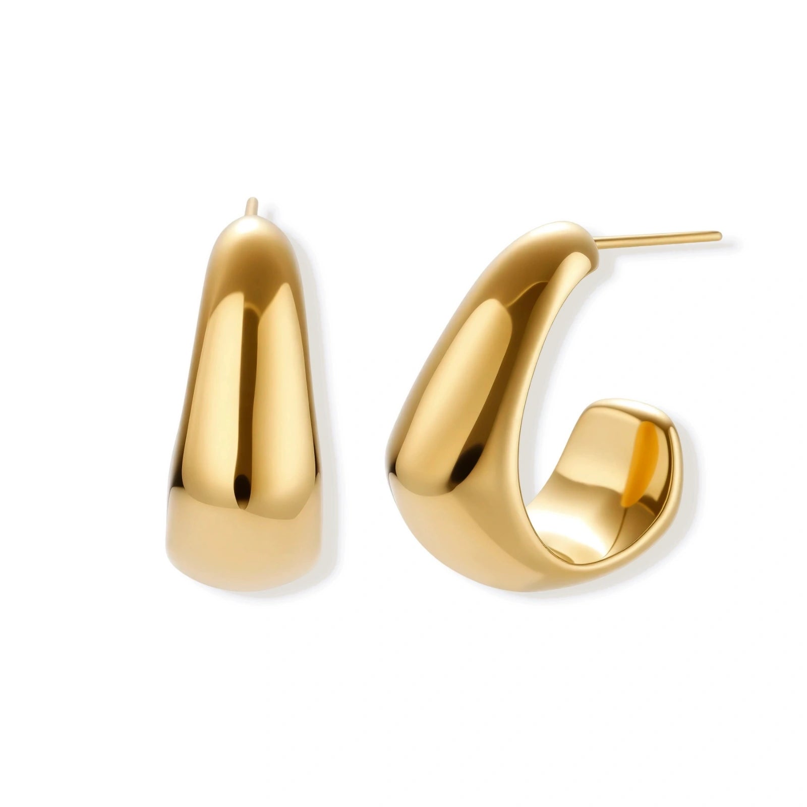 Close-up of curved gold-plated huggie earrings with sculptural design on white background, showing polished finish.