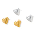 Pair of textured heart-shaped stud earrings in brushed platinum-plated sterling silver against cream background.