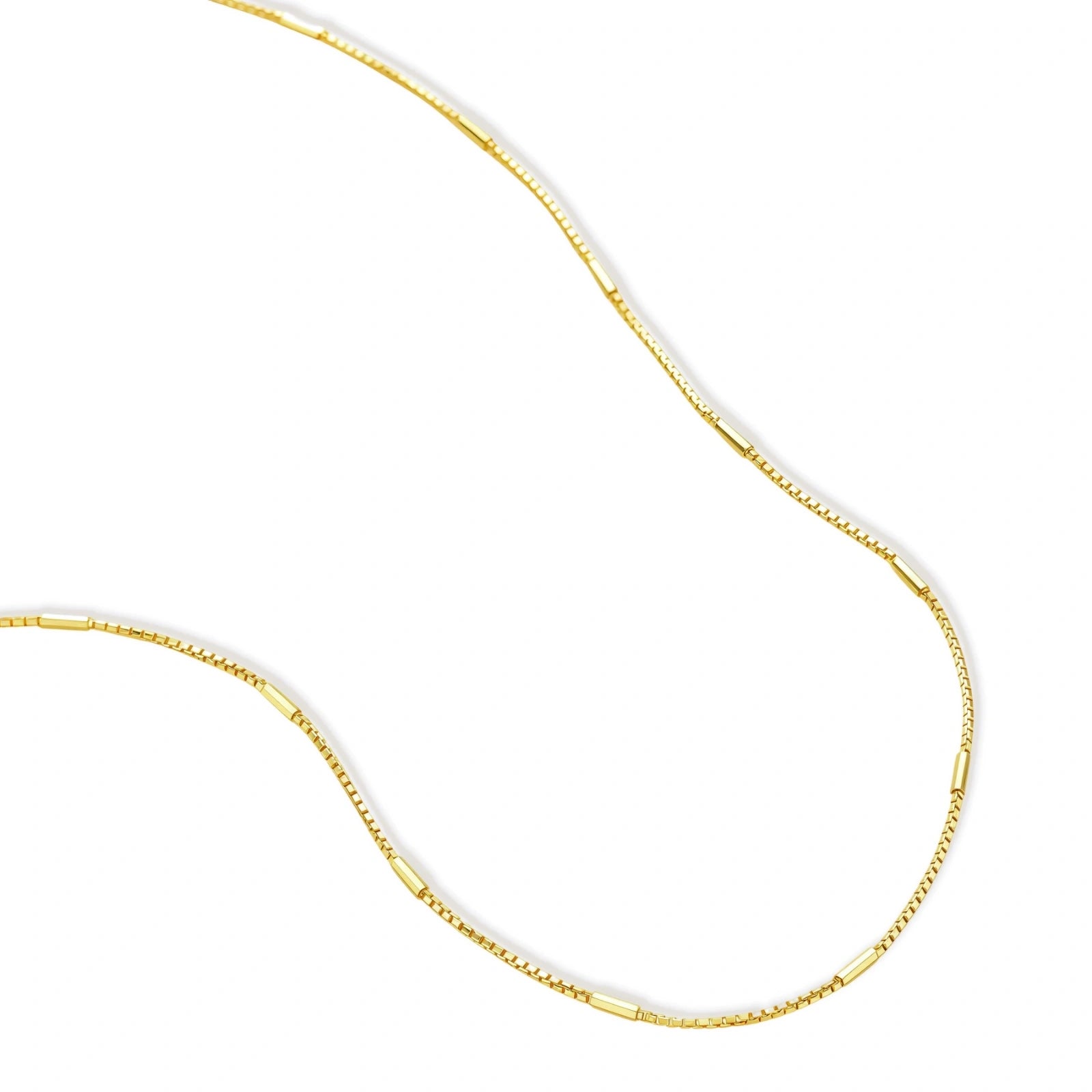 Delicate gold-plated sterling silver chain necklace with geometric segments displayed against cream background