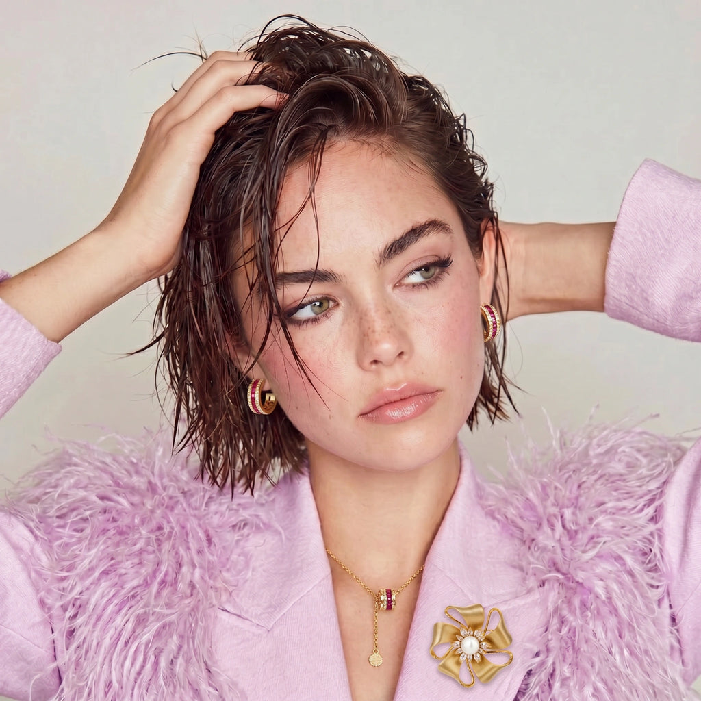 Woman wearing a pink outfit with a fluffy texture and gold jewelry against a light background