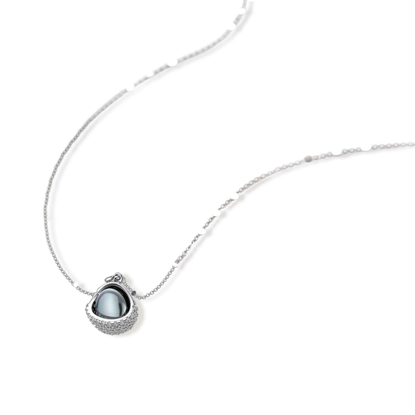 White gold plated spherical jewelry set with zirconia crystal pavé and dark lustrous centers on neutral background.