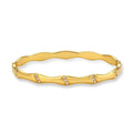 Gold-toned wavy bangle with bamboo-style segments and CZ crystal clusters on cream background. 18K plated stainless steel.