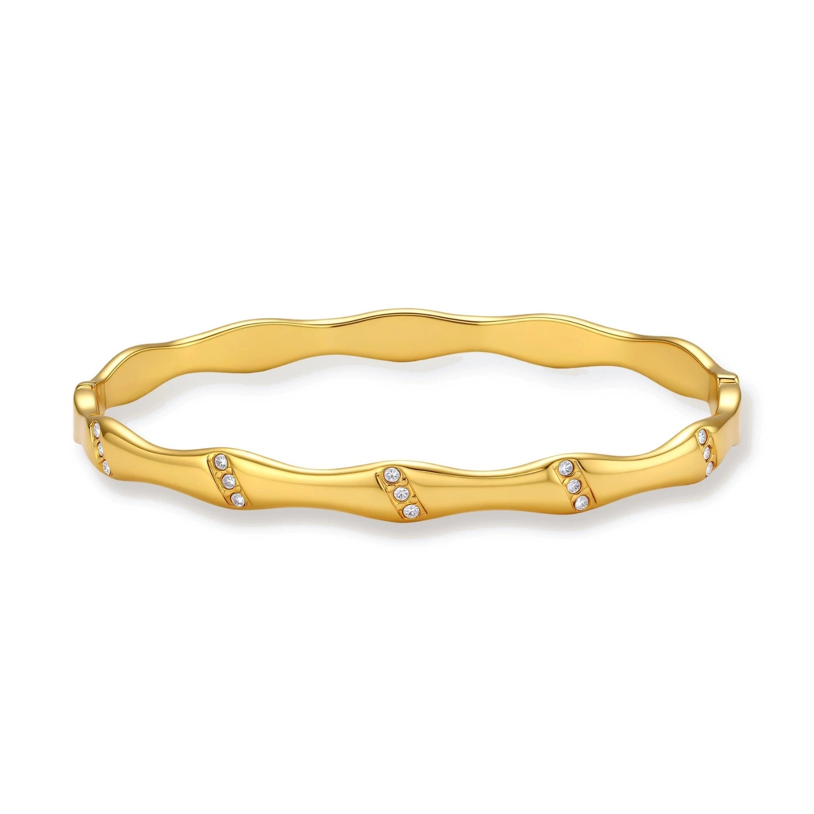 Gold-toned wavy bangle with bamboo-style segments and CZ crystal clusters on cream background. 18K plated stainless steel.