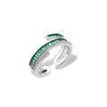 Modern adjustable ring with green baguette stones and clear crystals in parallel bands on white background.