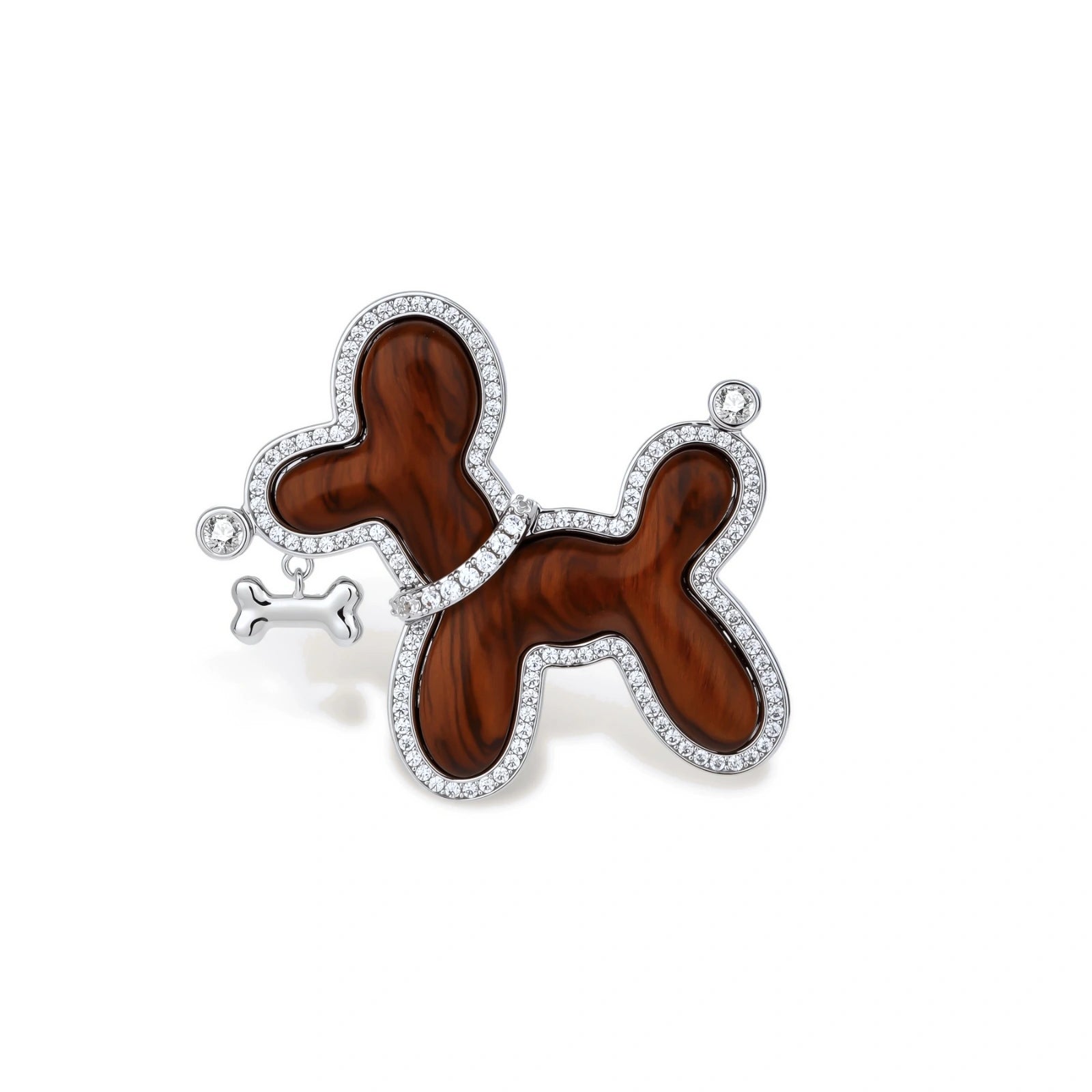 Dog-shaped brooch with copper base, palladium plating, crystal accents, and dangling bone charm against cream background